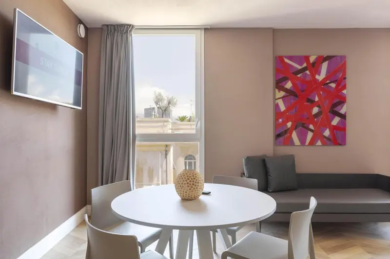 Une salle à manger lumineuse avec une table ronde et un canapé.