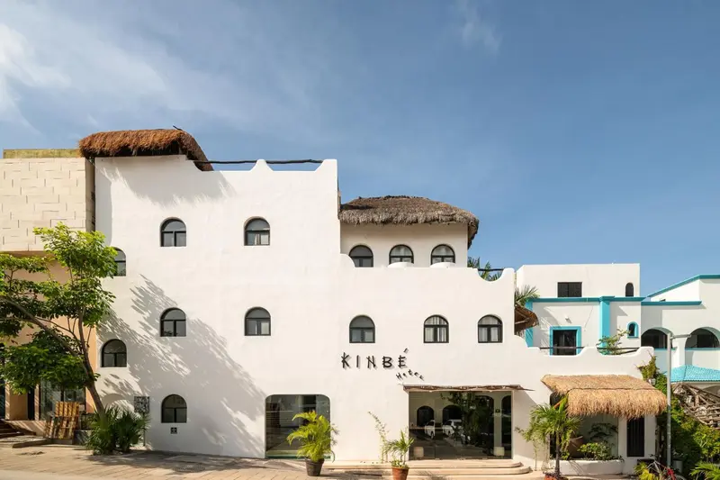 Bâtiment blanc à plusieurs fenêtres en arc d'un hôtel tropical.