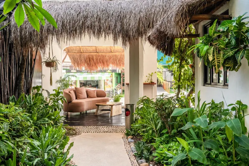 Un espace de détente extérieur avec un canapé et une végétation luxuriante.