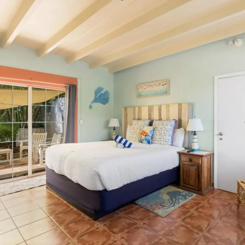 Une chambre lumineuse avec un grand lit et un accès à une terrasse.