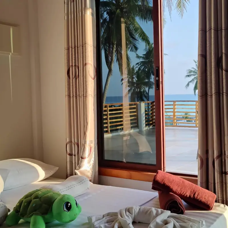 Une chambre lumineuse donne sur une terrasse et la mer.