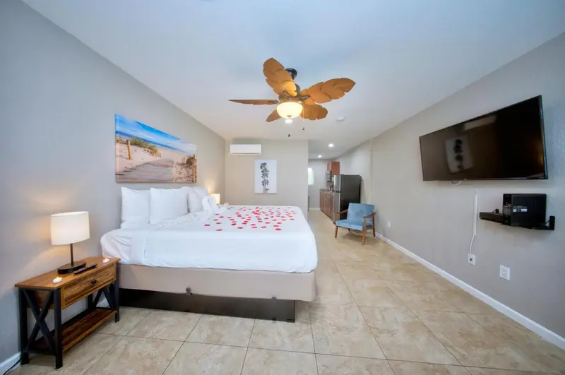 Une chambre lumineuse avec un grand lit recouvert de pétales de fleurs.