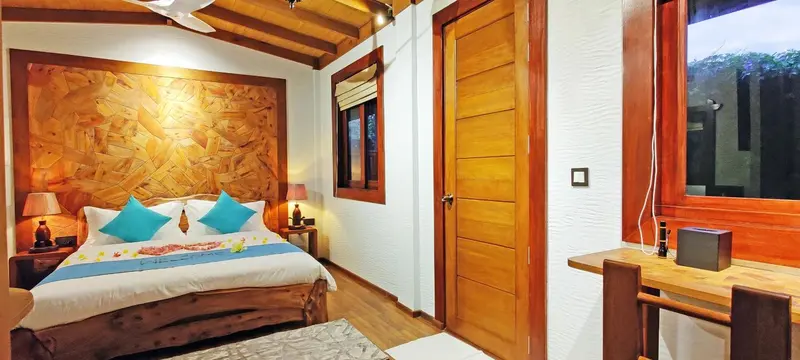 Une chambre lumineuse avec un grand lit et une décoration en bois.