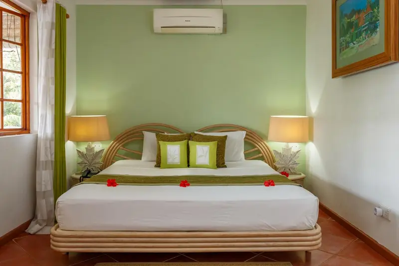 Une chambre lumineuse avec un grand lit décoré de fleurs.