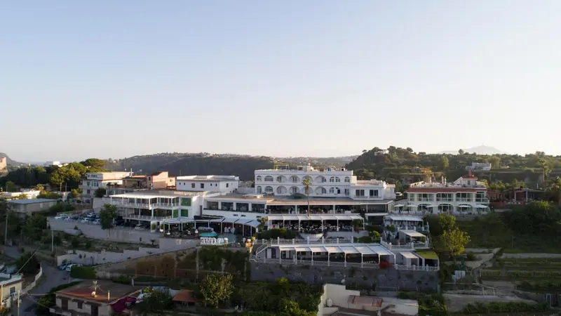 Vue aérienne d'un bâtiment blanc avec des terrasses et des espaces extérieurs.