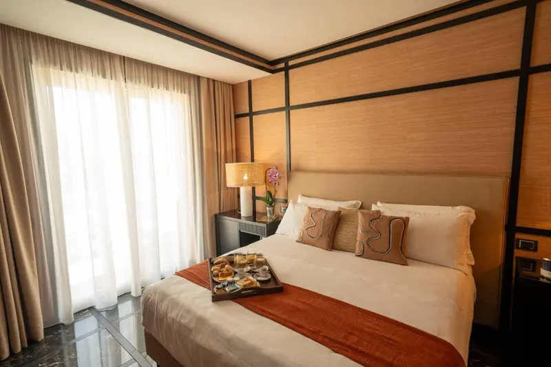 Une chambre d'hôtel avec un lit préparé et une table de chevet.