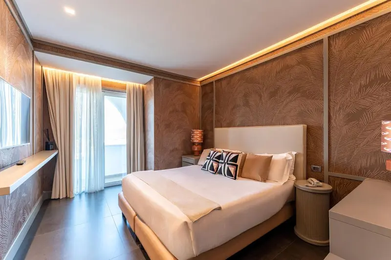 Une chambre lumineuse avec un grand lit et des rideaux blancs.