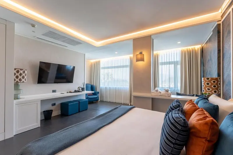 Une chambre moderne avec un grand lit et un téléviseur mural.