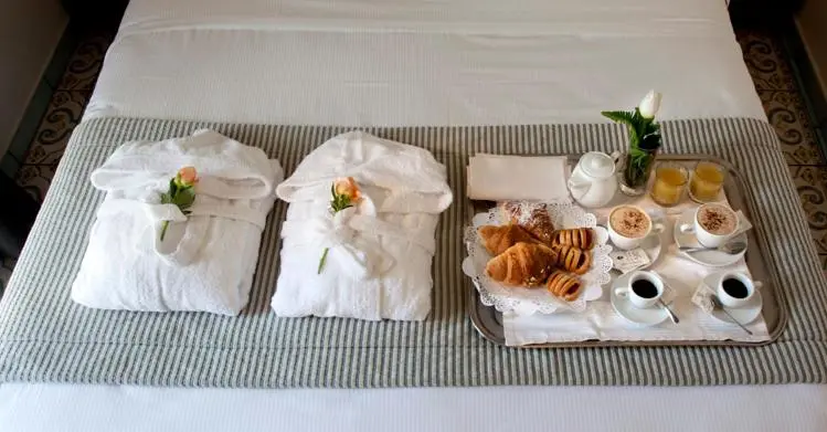 Un petit-déjeuner est servi sur un lit préparé avec soin.