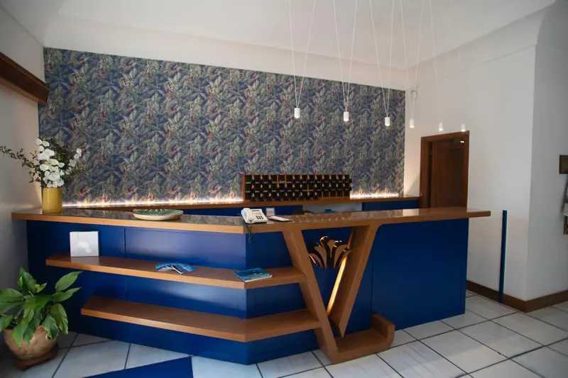 Un comptoir d'accueil moderne avec un décor floral mural.