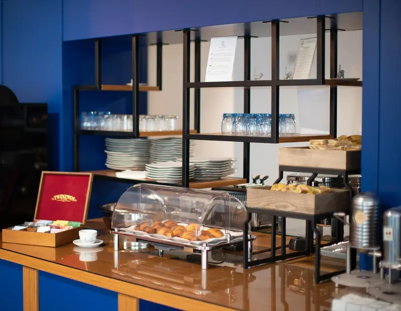 Un comptoir de buffet propose des viennoiseries et des boissons.