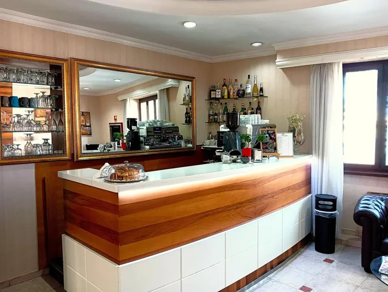 Un comptoir de bar en bois clair avec des bouteilles et des verres.
