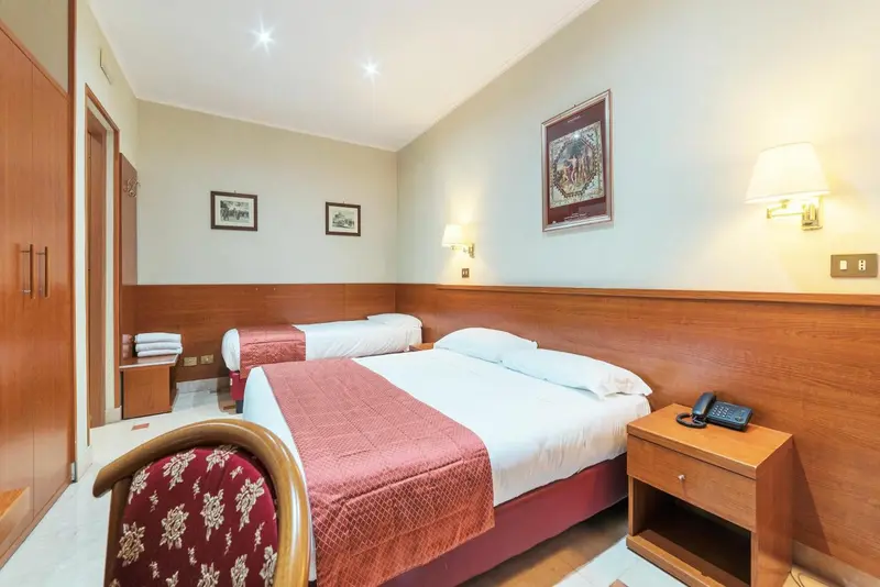 Une chambre d'hôtel avec deux lits simples et des meubles en bois.