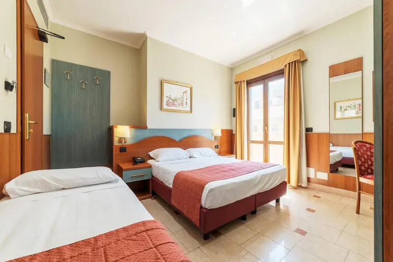 Chambre avec deux lits et une commode en bois.