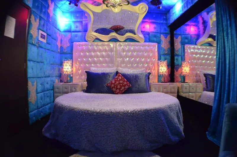 Une chambre à coucher décorée dans des tons bleus et blancs avec un grand lit à baldaquin.