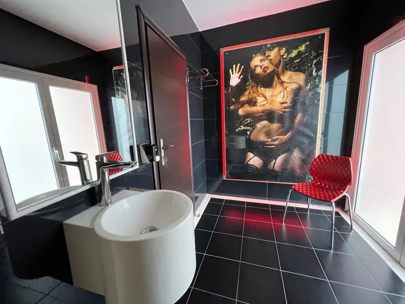 Une salle de bain moderne avec une douche à l'italienne et un grand tableau décoratif.