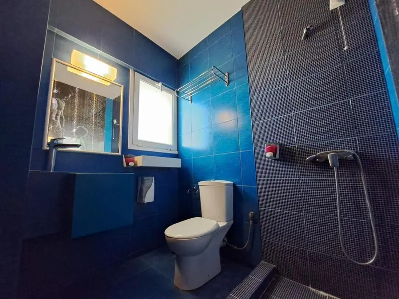 Une salle de bain moderne avec des carreaux bleus et une douche.