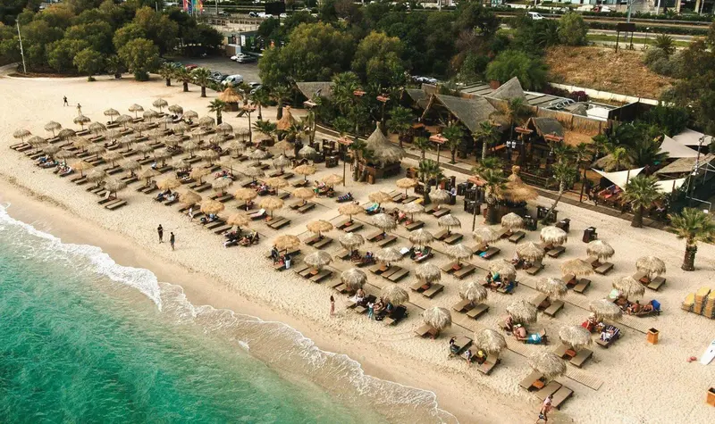Vue aérienne d'une plage aménagée avec des transats et des parasols.