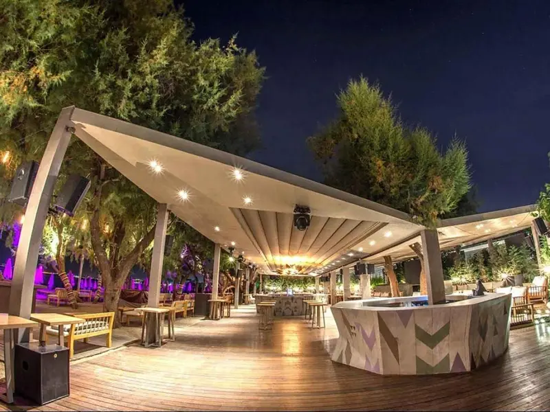 Terrasse lumineuse avec mobilier de détente et bar.