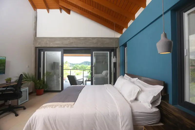 Une chambre lumineuse avec un grand lit et un accès à une terrasse.