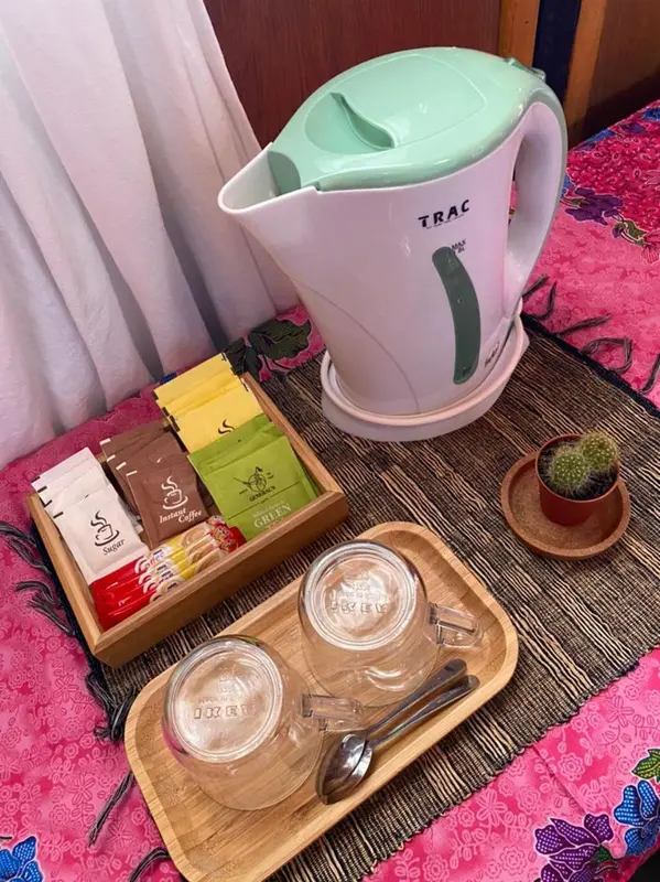 Une bouilloire électrique et des sachets de thé sont posés sur une table.