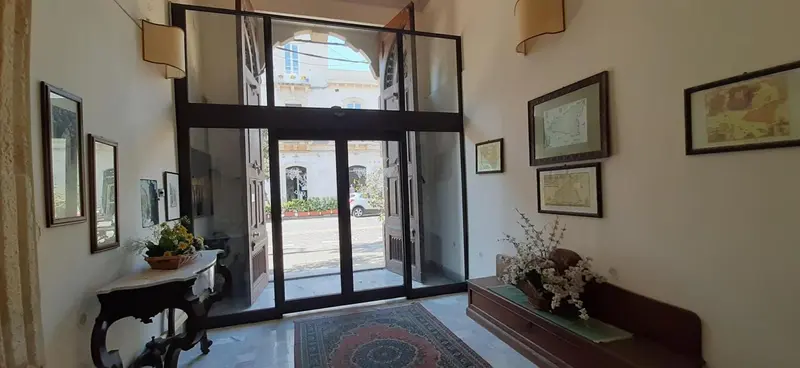 Hall d'entrée lumineux avec des miroirs et des tableaux décoratifs.