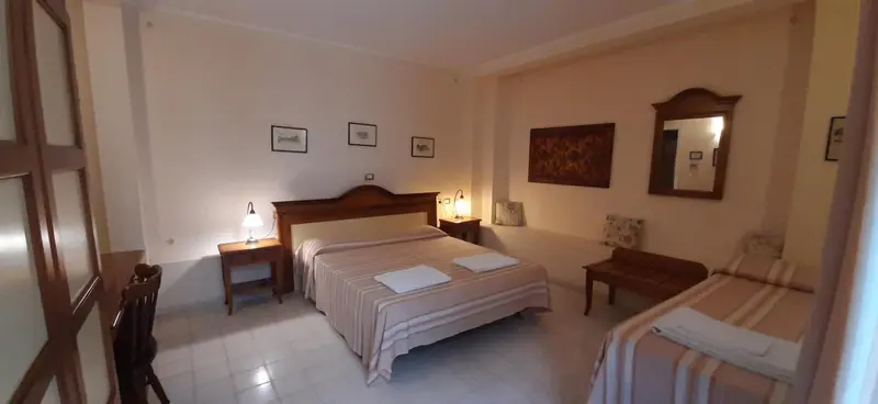 Une chambre lumineuse avec un grand lit et un lit d'appoint.