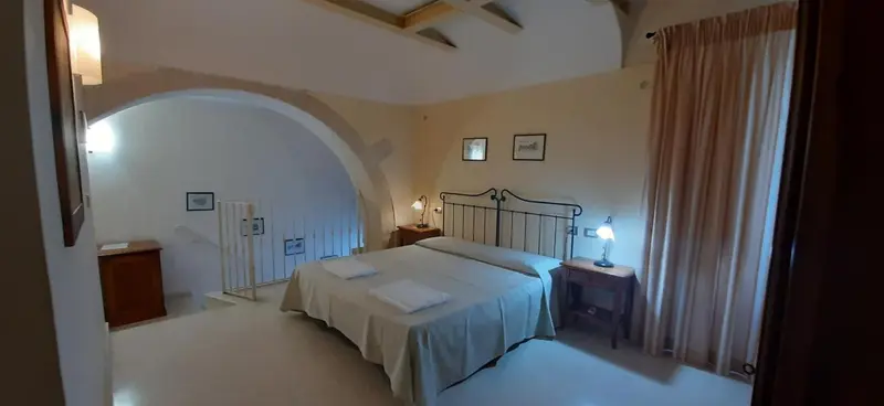 Une chambre à coucher lumineuse avec un lit à baldaquin et des murs blancs.