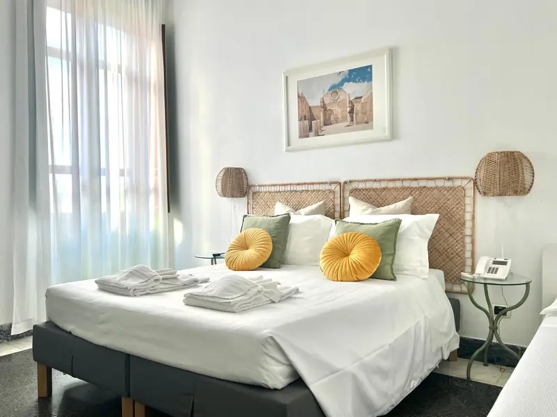 Une chambre lumineuse avec un grand lit et une décoration naturelle.