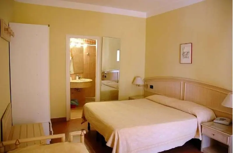 Une chambre lumineuse avec un lit et un accès à une salle de bain.