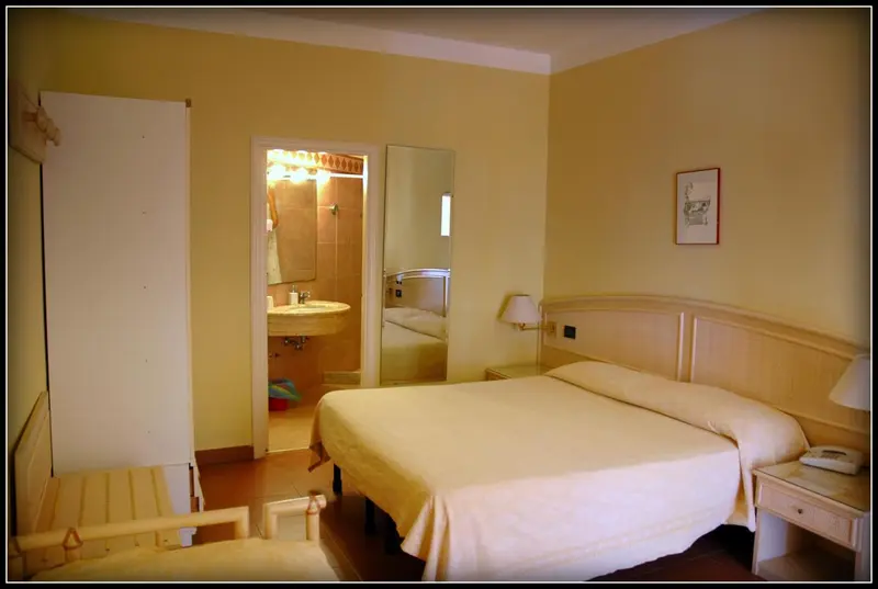 Une chambre lumineuse avec un grand lit et un accès à une salle de bain.