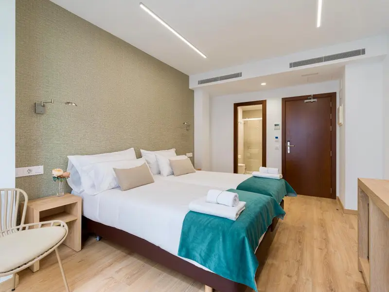 Une chambre lumineuse avec un grand lit et une décoration sobre.