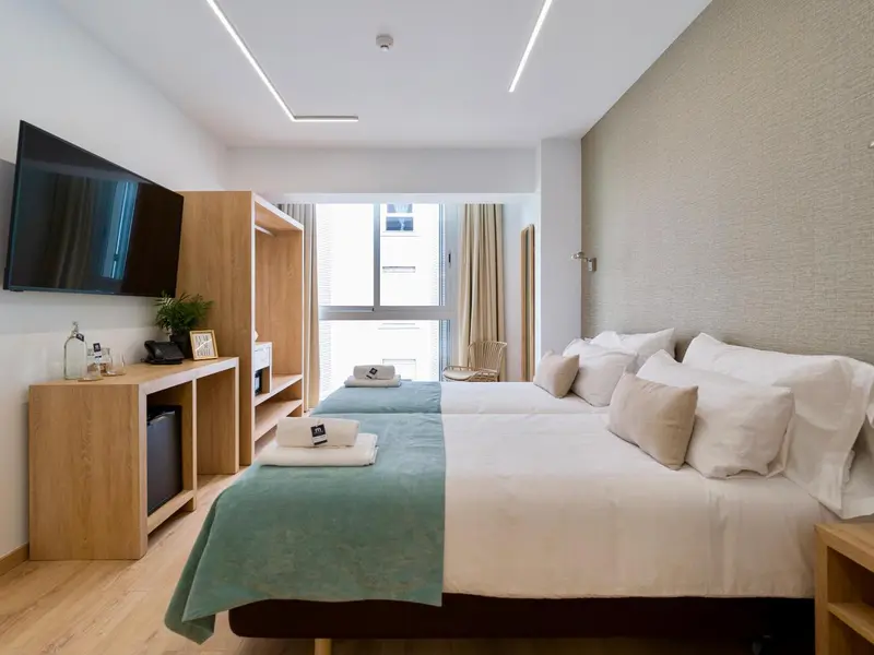 Une chambre lumineuse avec un grand lit et un bureau.