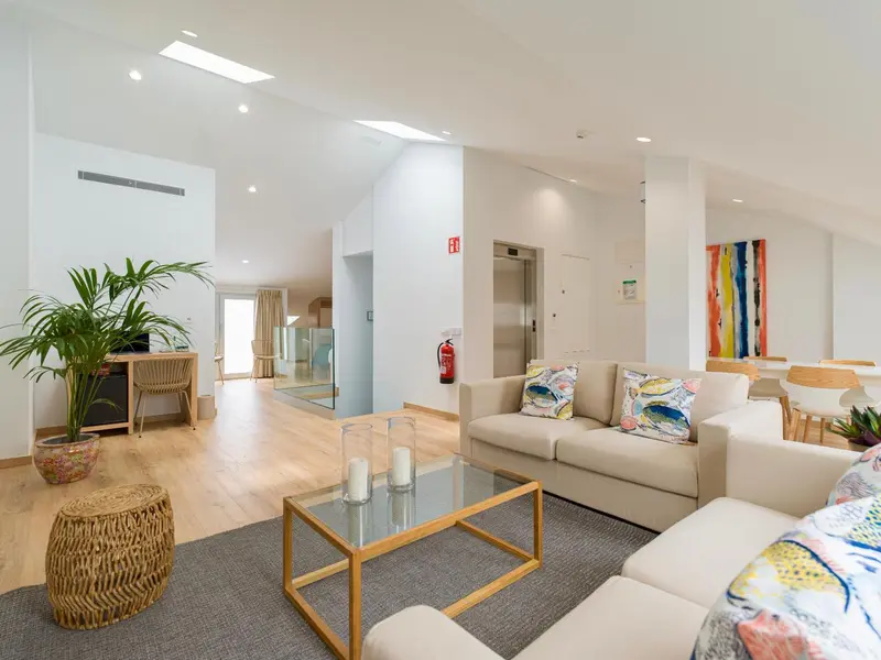 Espace de séjour lumineux avec canapés et décoration colorée.