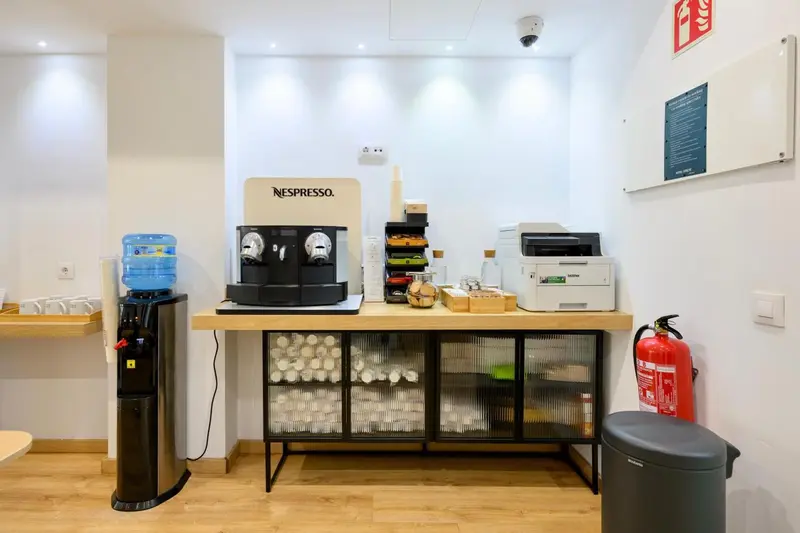 Un comptoir propose des boissons chaudes et froides avec des tasses et des accessoires.