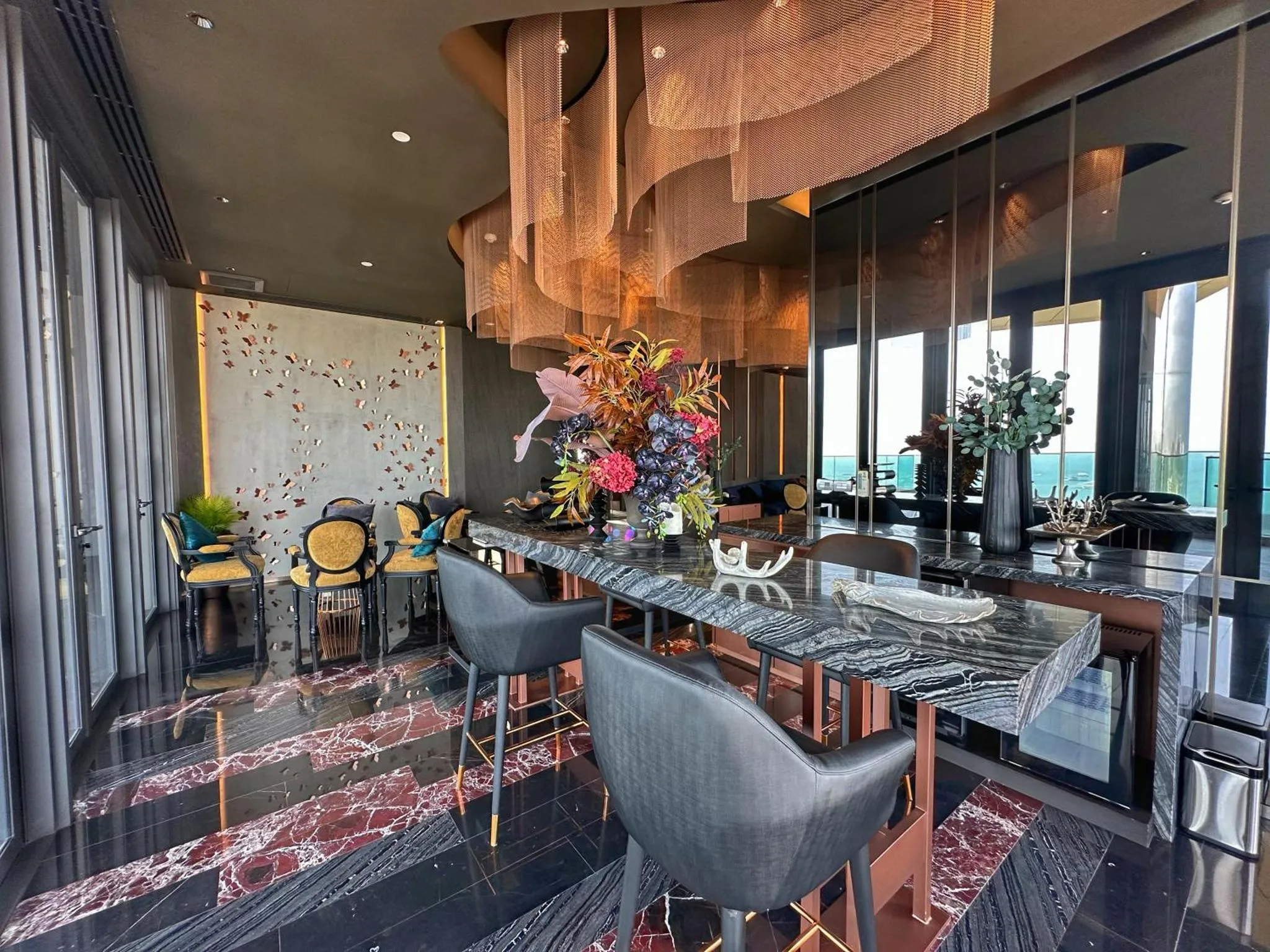 Un bar élégant avec un comptoir en marbre et des arrangements floraux.