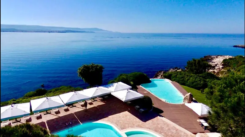 Terrasse avec plusieurs piscines et vue sur la mer.