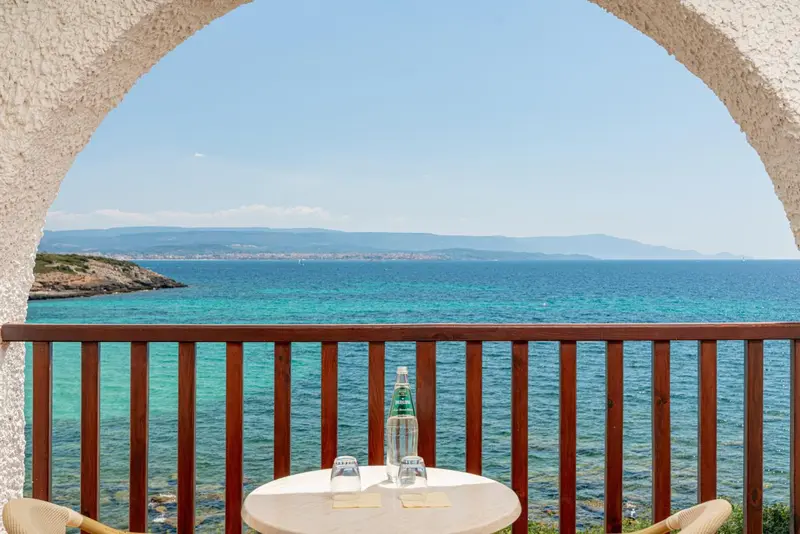 Vue sur la mer depuis une terrasse avec une table et des chaises.