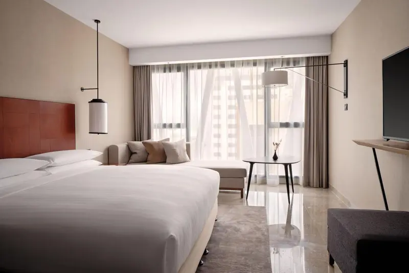 Une chambre lumineuse avec un grand lit et une fenêtre.