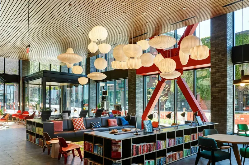 Espace de détente intérieur avec canapés, fauteuils et bibliothèque.