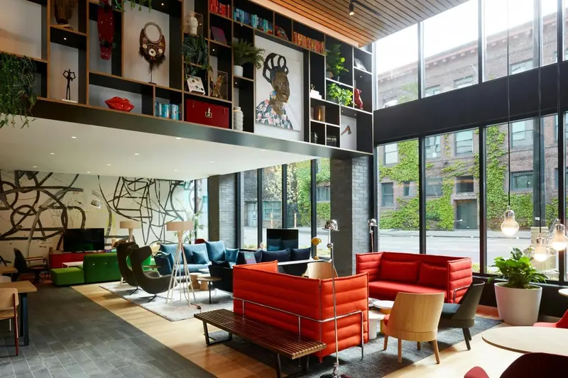Un espace de détente intérieur avec des canapés colorés et une bibliothèque murale.