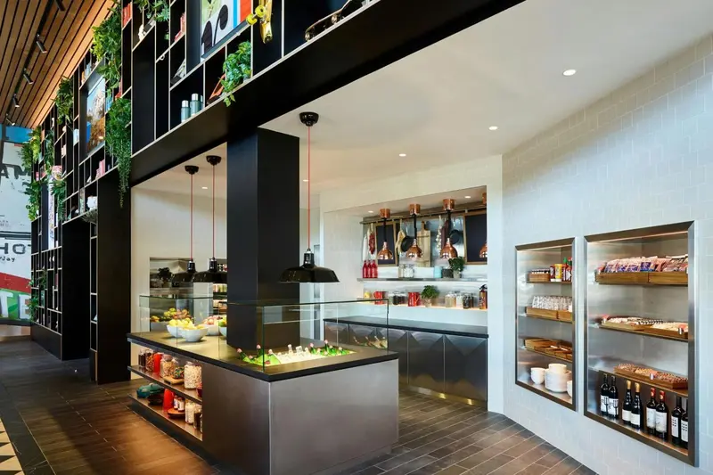 Un comptoir de vente présente des produits alimentaires et des boissons dans un espace lumineux.