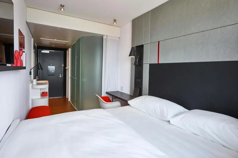 Une chambre moderne avec un lit blanc et un bureau.