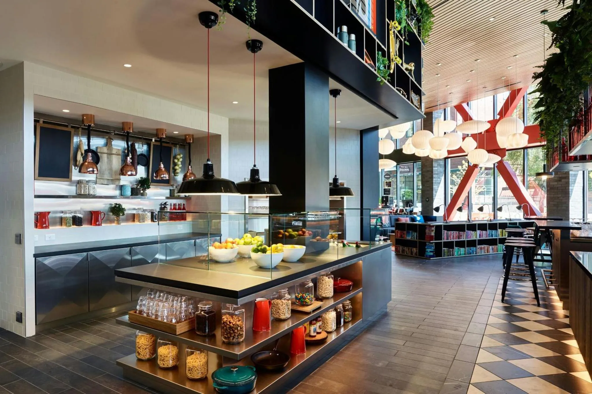 Un buffet propose des fruits, des céréales et des pâtisseries dans une salle lumineuse.