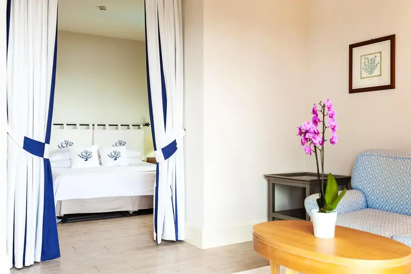 Une chambre lumineuse avec un lit et un espace salon.