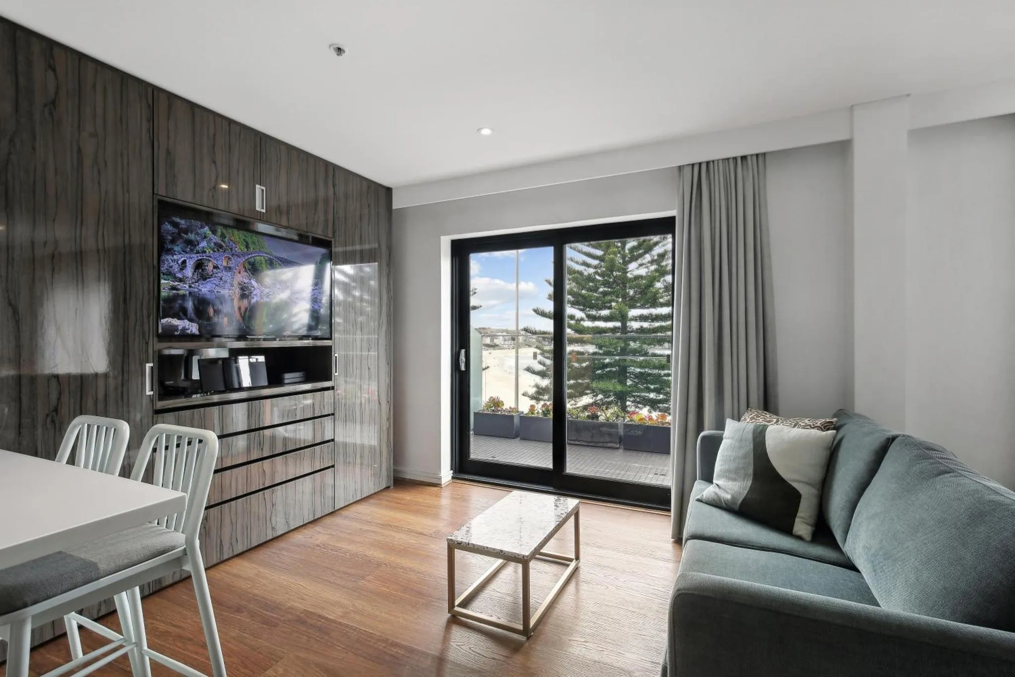 Un salon moderne s'ouvre sur une terrasse avec vue sur la mer.