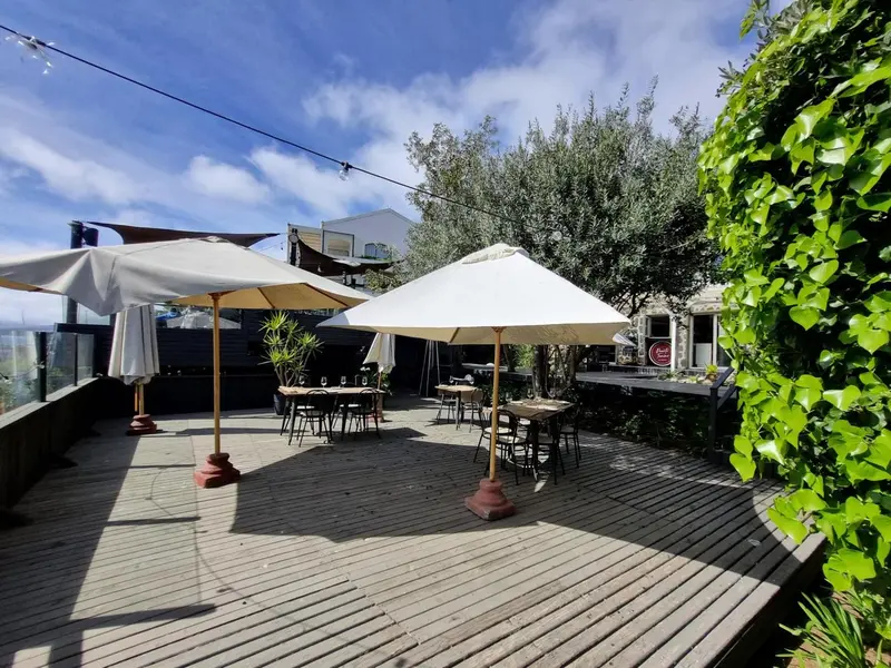 Terrasse en bois avec parasols et mobilier de jardin.