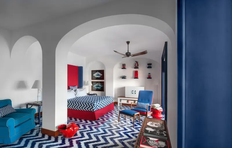 Une chambre à coucher colorée avec un lit et des fauteuils.