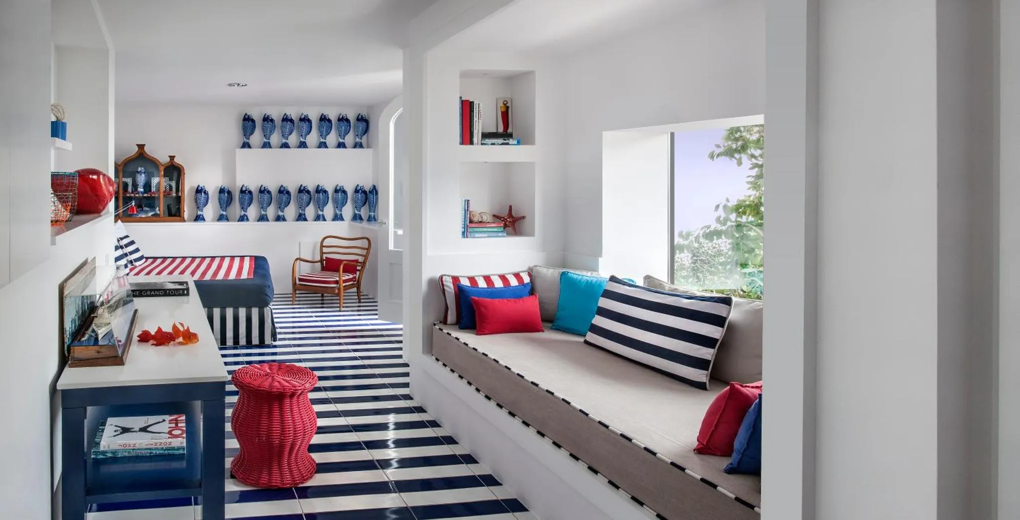 Espace de détente intérieur avec banquettes rayées et décorations maritimes.