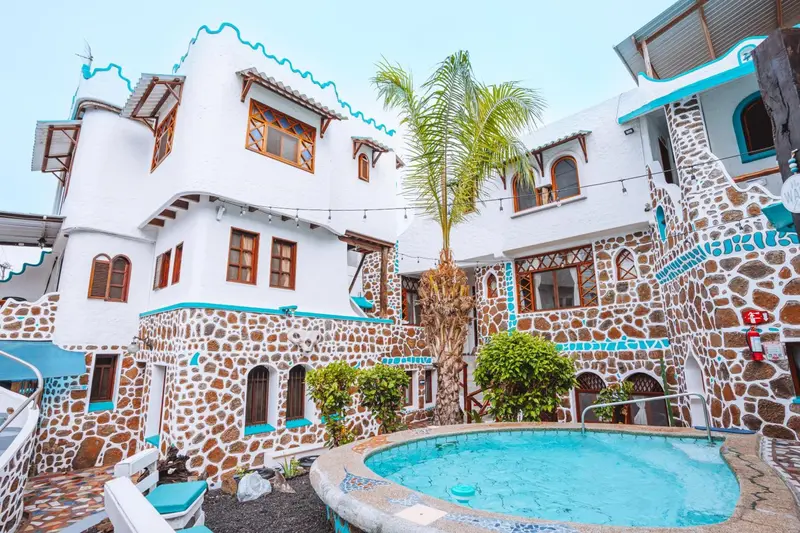 Bâtiment blanc et coloré avec une petite piscine en contrebas.